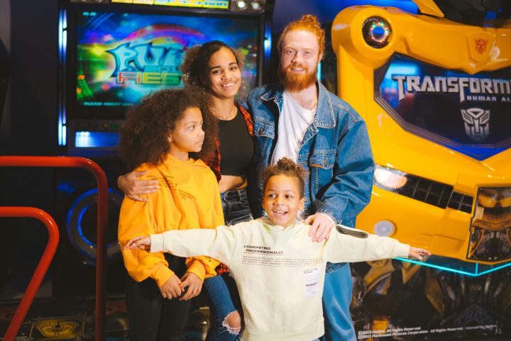 A Family Standing Near the Video Game Machines